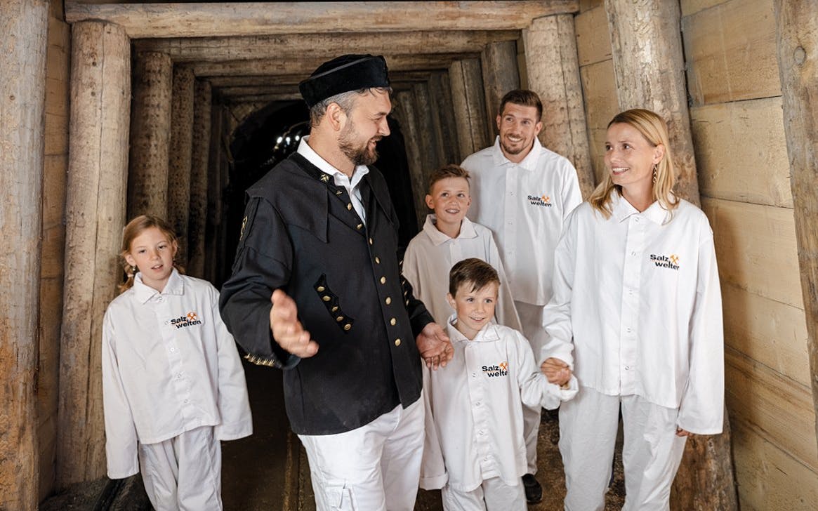 Tour group exploring Hallein salt mines in Salzburg with a guide.