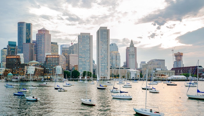 Boston Harbor with sailboats and city skyline in the background.
