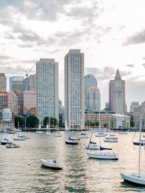 Boston Harbor with sailboats and city skyline in the background.