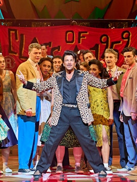 London theatre stage with audience, showcasing discounted tickets for a captivating performance.