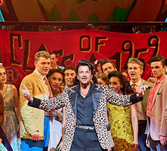 London theatre stage with audience, showcasing discounted tickets for a captivating performance.