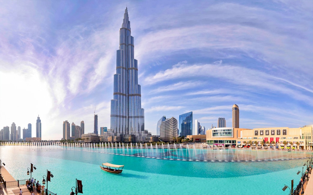Burj Khalifa towering over Dubai Fountain with city skyline in the background.