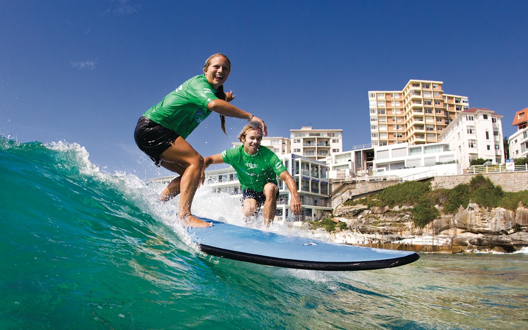 Surfers riding a wave during a lesson at Bondi Beach, Sydney.