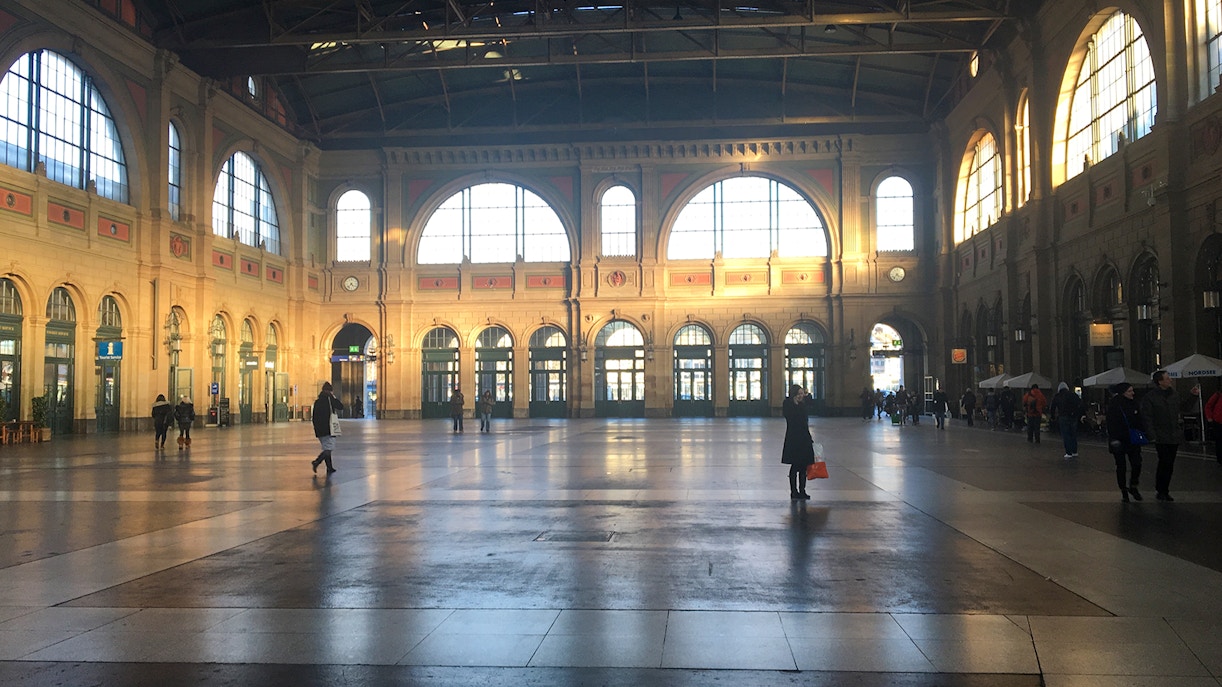 Zurich train station interior with travelers walking through the spacious hall.