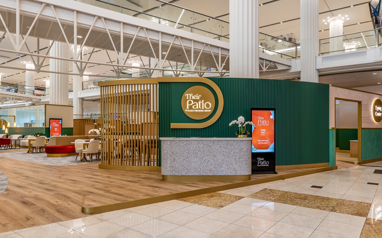 Premium lounge entrance at Dubai International Airport with seating area and reception desk.