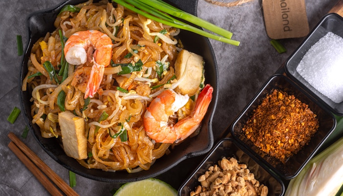 Pad Thai dish with shrimp and lime in a traditional Thai setting, Thailand.