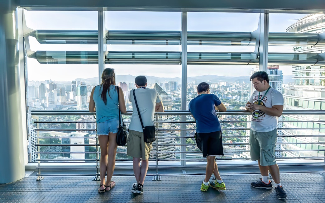 Visitors enjoying the view from Petronas Twin Towers skybridge in Kuala Lumpur.