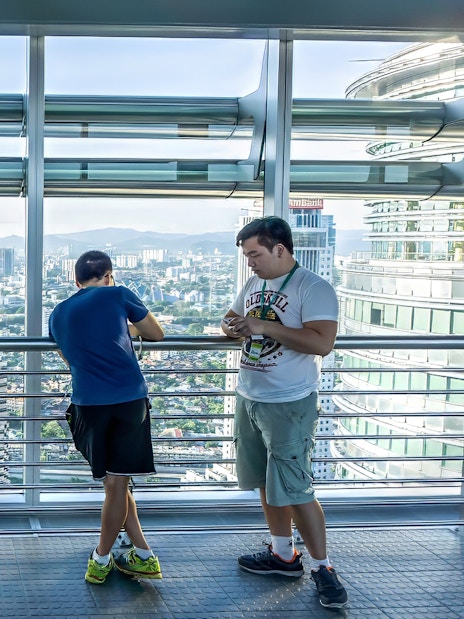 Visitors enjoying the view from Petronas Twin Towers skybridge in Kuala Lumpur.