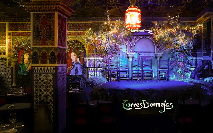 Flamenco stage at Torres Bermejas, Madrid, with ornate decor and empty chairs.