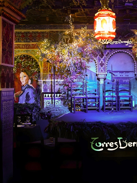 Flamenco stage at Torres Bermejas, Madrid, with ornate decor and empty chairs.