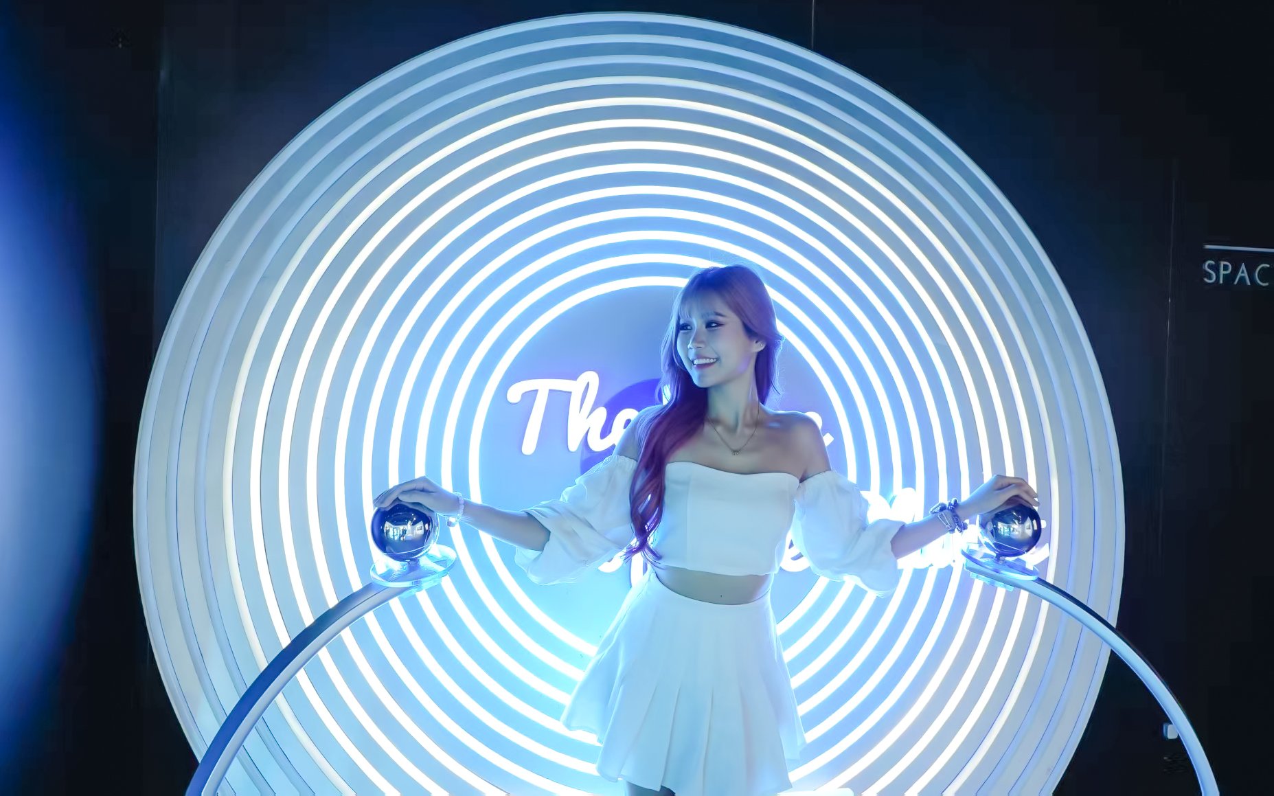 Person interacting with a futuristic light display at Space & Time Cube in Bangkok.