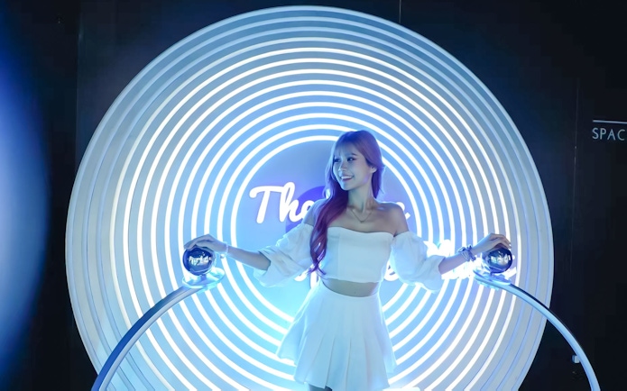 Person interacting with a futuristic light display at Space & Time Cube in Bangkok.