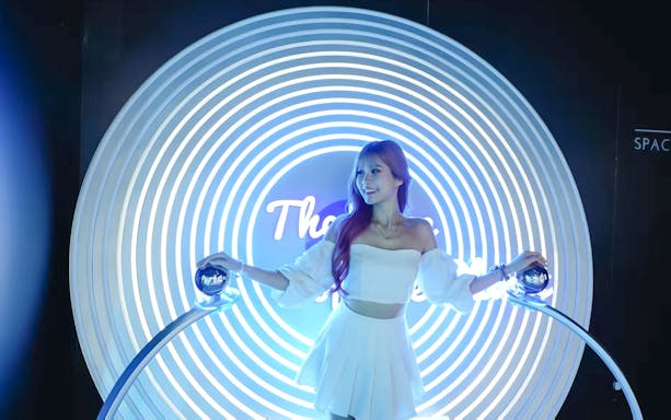 Person interacting with a futuristic light display at Space & Time Cube in Bangkok.