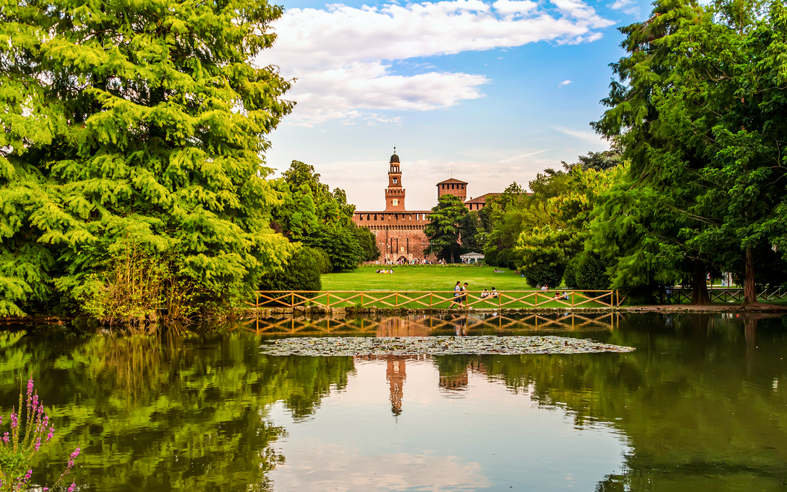 Sforza Castle seen from Parco Sempione, Milan, Italy, with lush greenery in the foreground.