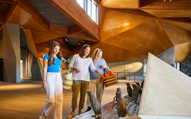 Visitors observing penguin sculptures at Penguin Parade Visitor Centre.