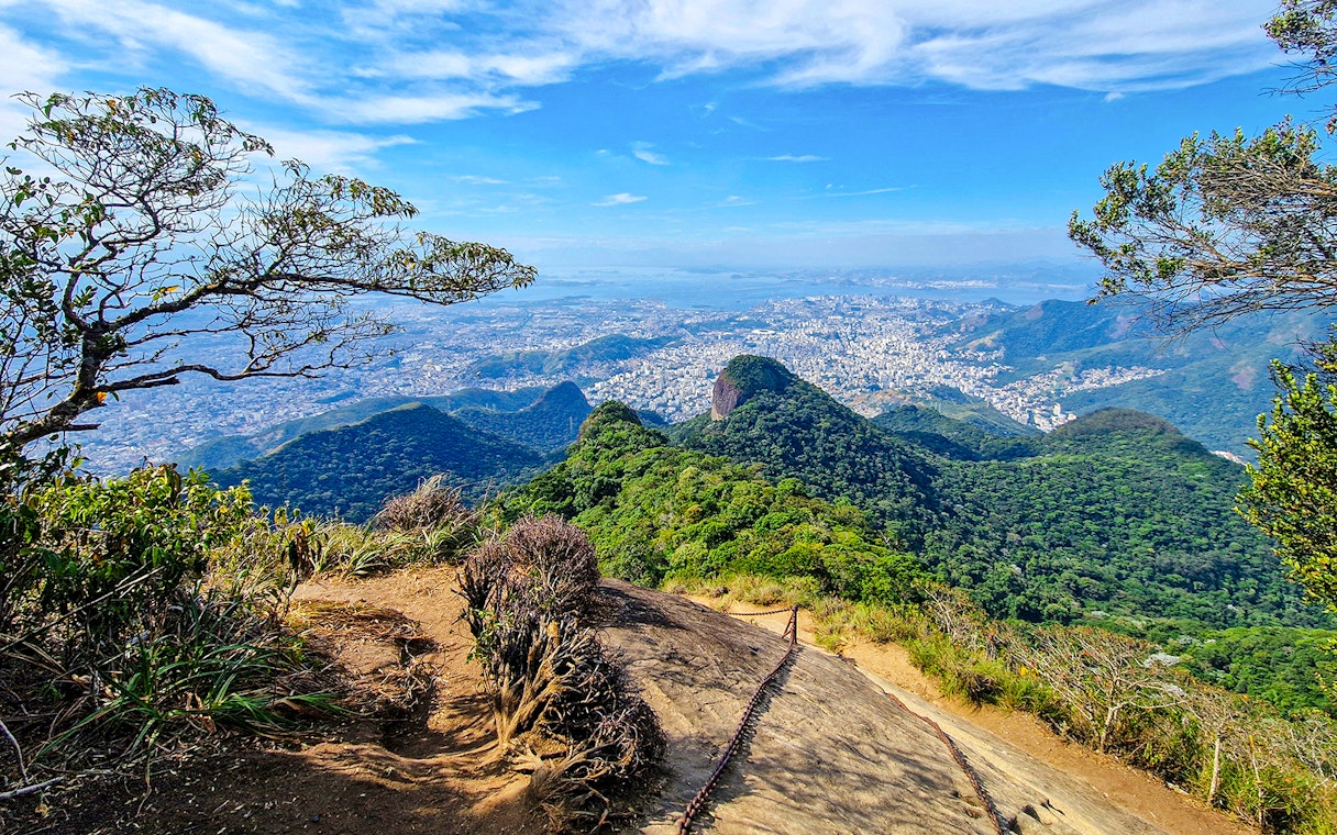 Tijuca National Park view with lush green hills and cityscape in the distance.