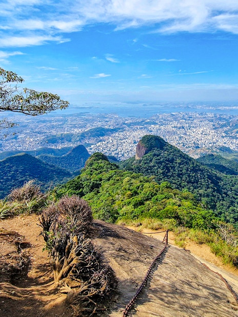 Tijuca National Park view with lush green hills and cityscape in the distance.