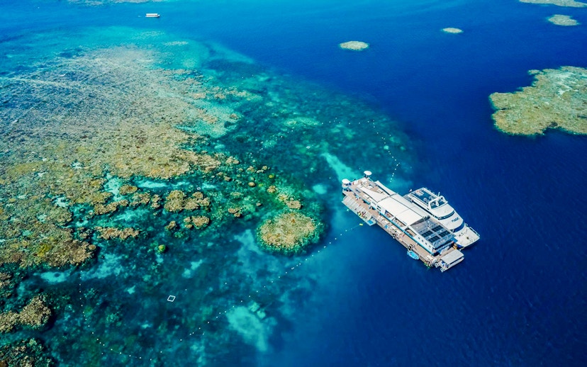 Aerial view of a pontoon at the Great Barrier Reef surrounded by vibrant coral formations.