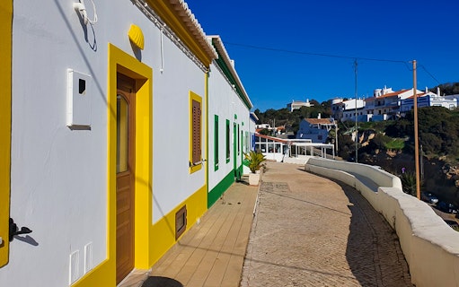 Colorful houses along a cobblestone street in Algarve, Portugal.