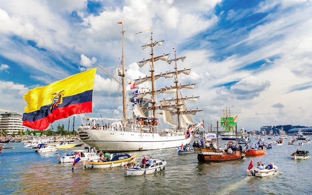 Tall ships and boats sailing during Sail Amsterdam event.