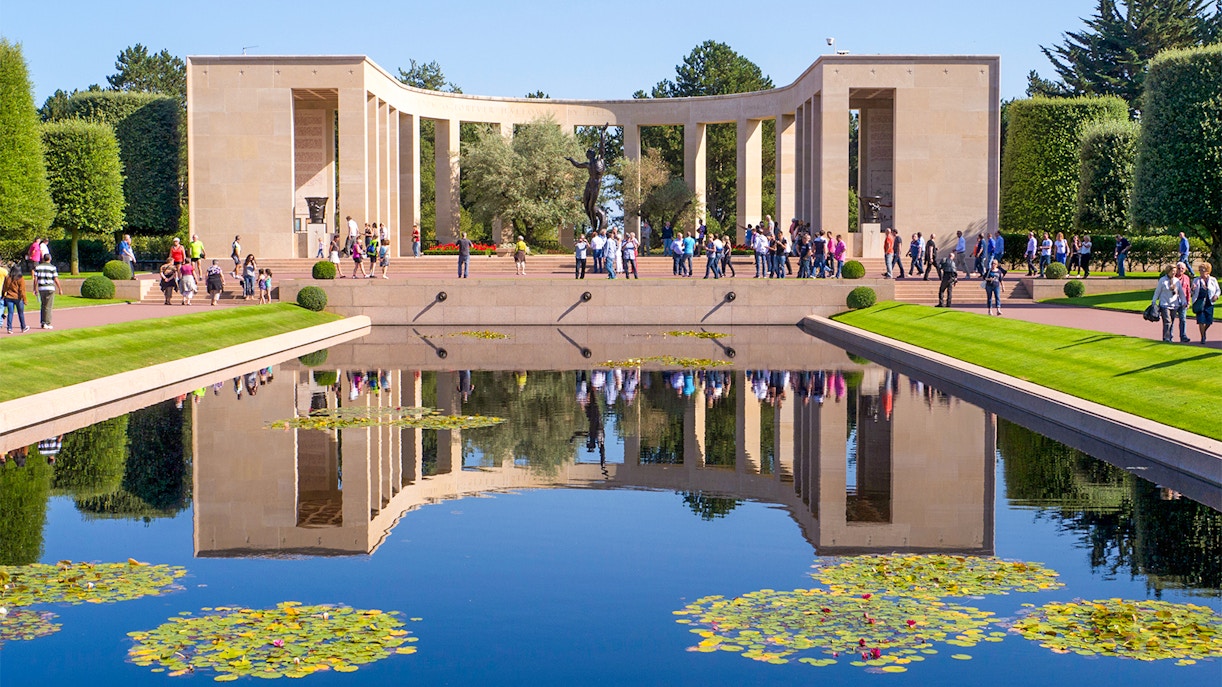 Normandy D-Day Tours guide explaining historical site with visitors in Normandy, France.