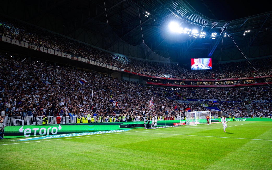 Crowd cheering during a night match at Olympique Lyonnais OL stadium, Lyon, France.