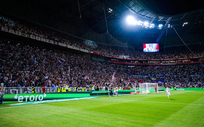 Crowd cheering during a night match at Olympique Lyonnais OL stadium, Lyon, France.
