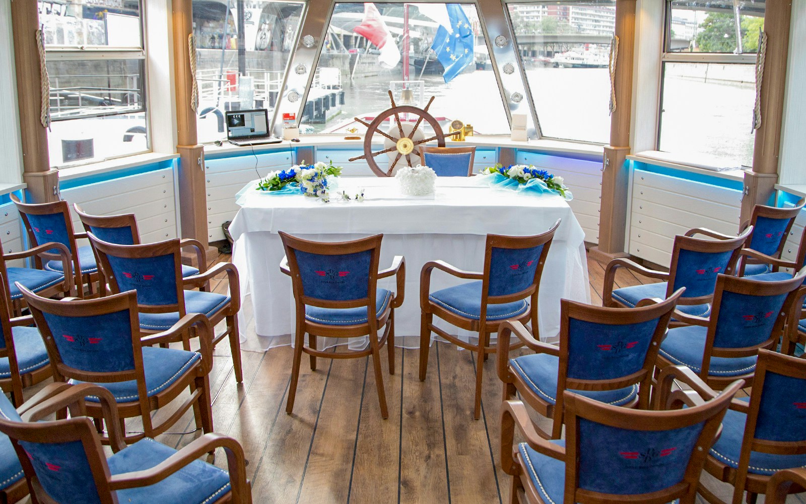 Interior of a Danube Canal cruise ship with arranged seating and a decorated table.