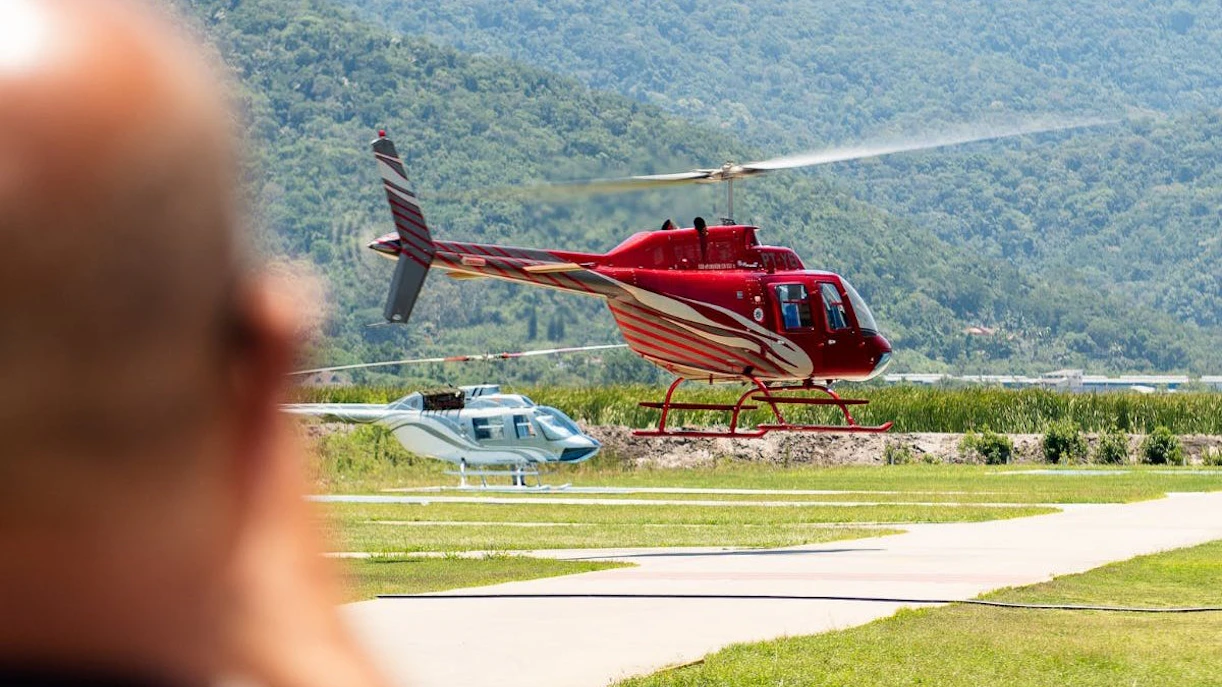 Helicopter taking off during Rio de Janeiro tour with mountains in the background.