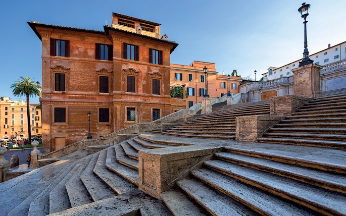 Spanish Steps in Rome with historic buildings in the background.