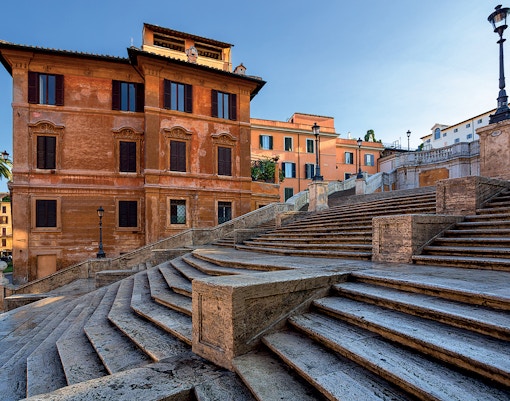 Spanish Steps in Rome with historic buildings in the background.