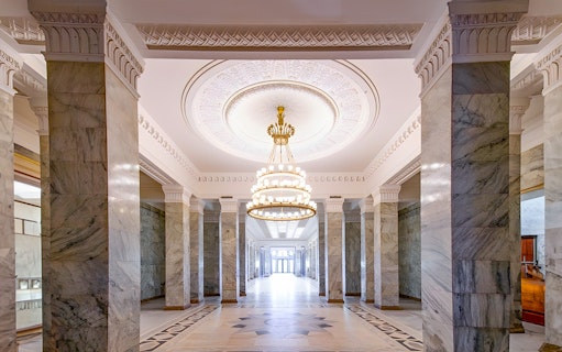 Palace of Culture and Science lobby with marble columns and ornate chandelier.