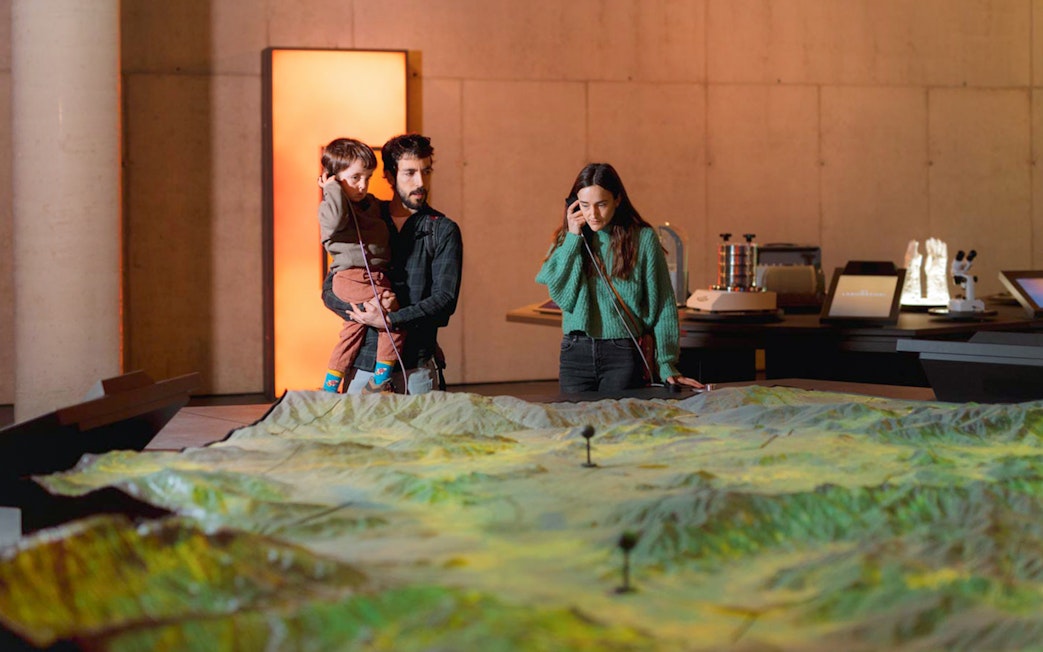 Family exploring interactive exhibit at Espai Crater.