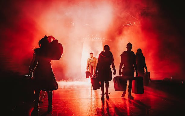Performers on stage in dramatic lighting during Come Alive Westend show.