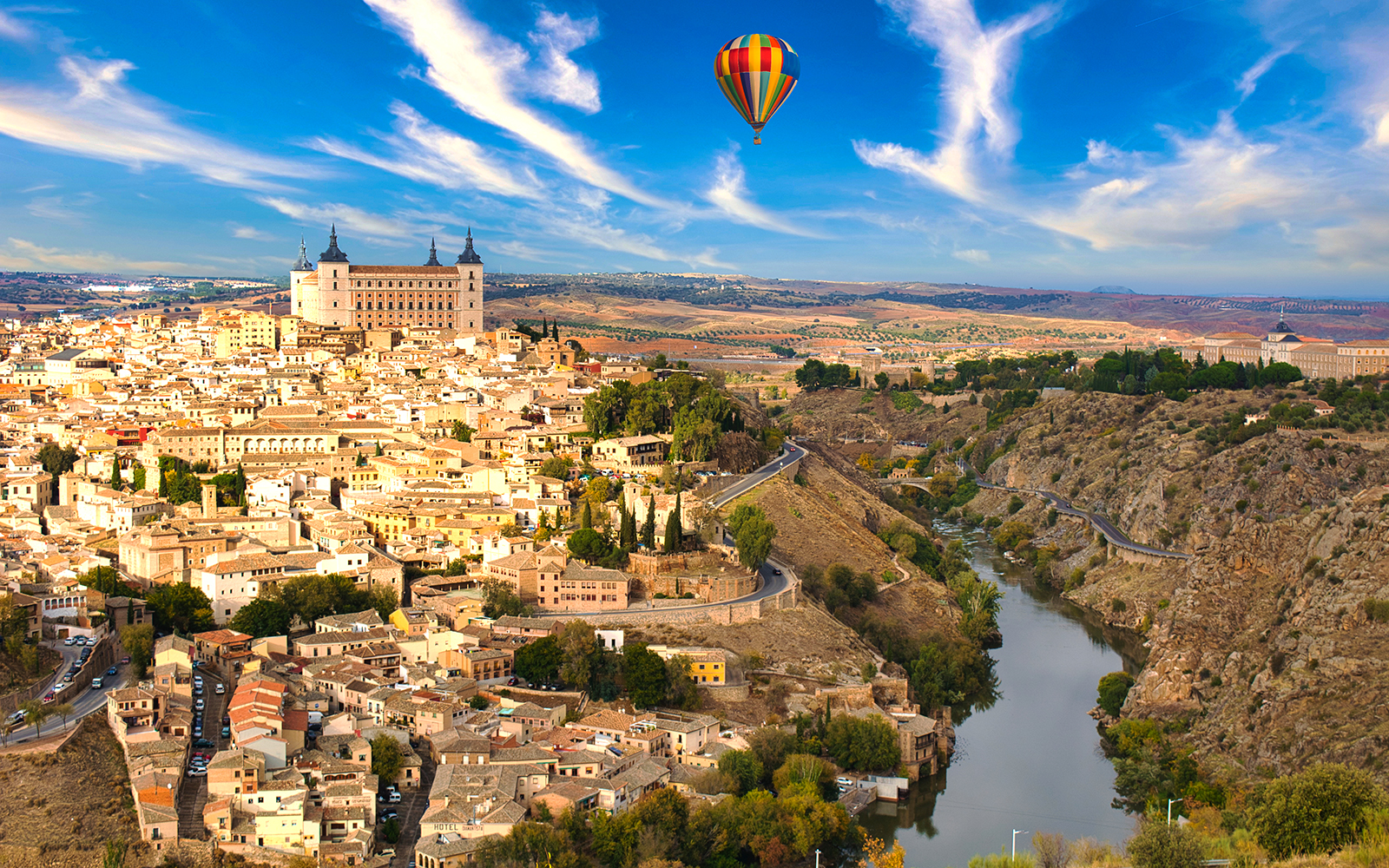 Hot air balloon over Toledo, Spain, showcasing cityscape and historic landmarks.