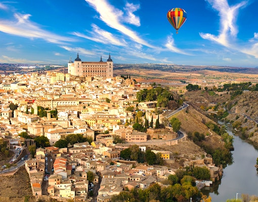 Hot air balloon over Toledo, Spain, showcasing cityscape and historic landmarks.