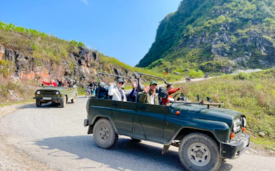 Tourists in a jeep on a scenic mountain road during the Sapa Jeep Half Day Tour, Sa Pa.