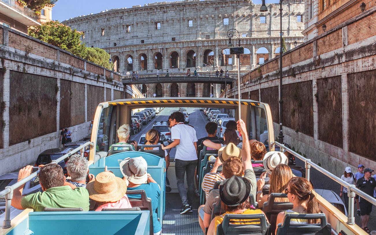 Open-top bus tour near the Colosseum in Rome, Italy.