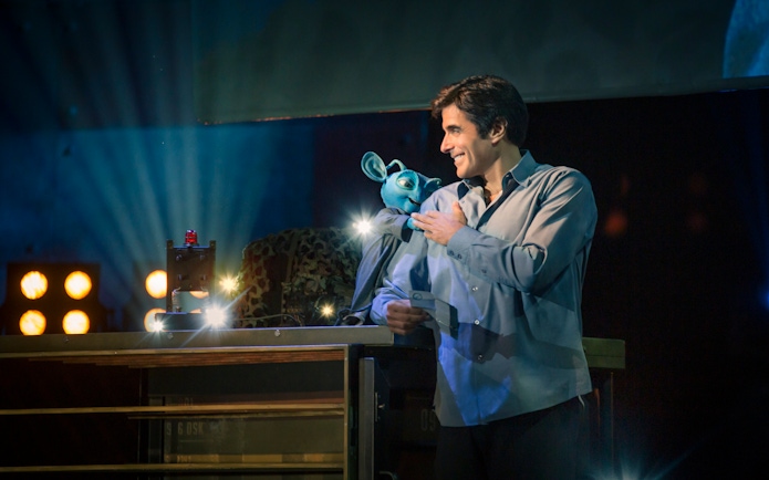 Magician performing with puppet during David Copperfield Vegas show.