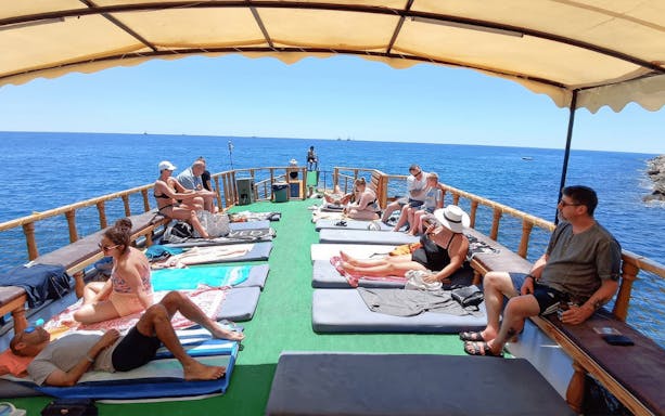 People relaxing on a boat deck during the Alanya Relaxing Boat Tour, with a view of the sea.