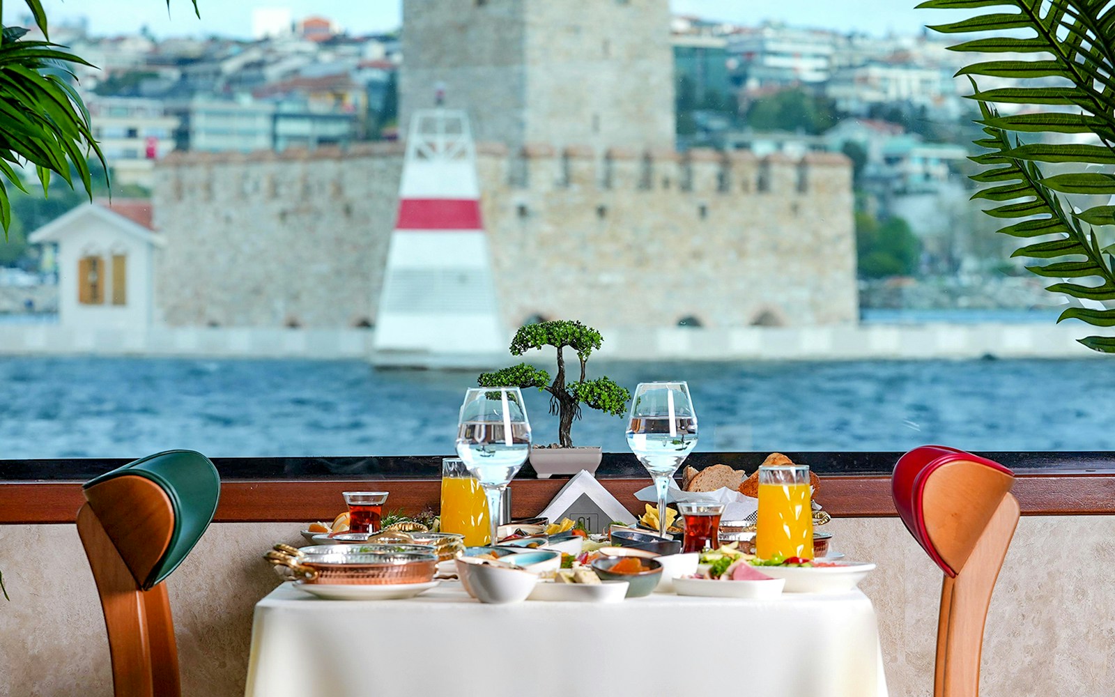 Private table with drinks and brunch overlooking Bosphorus, Istanbul, during cruise.