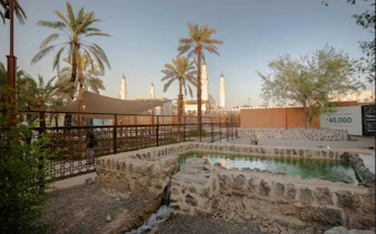 Courtyard with palm trees and stone water feature near Quba Mosque, Medina.