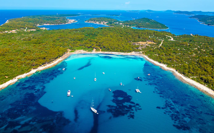 Aerial view of Sakarun Beach with boats on turquoise water, Dugi Otok, Croatia.