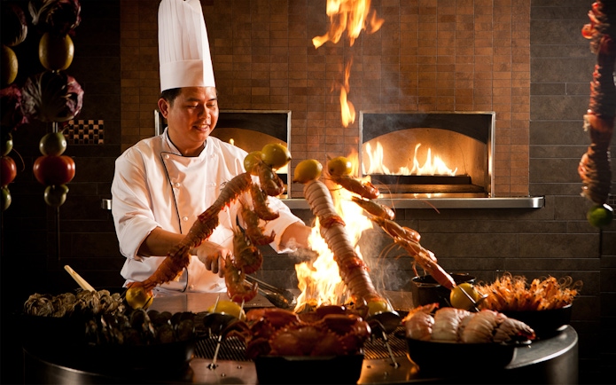 Chef grilling seafood skewers at Atlantis the Palm's buffet, Dubai.