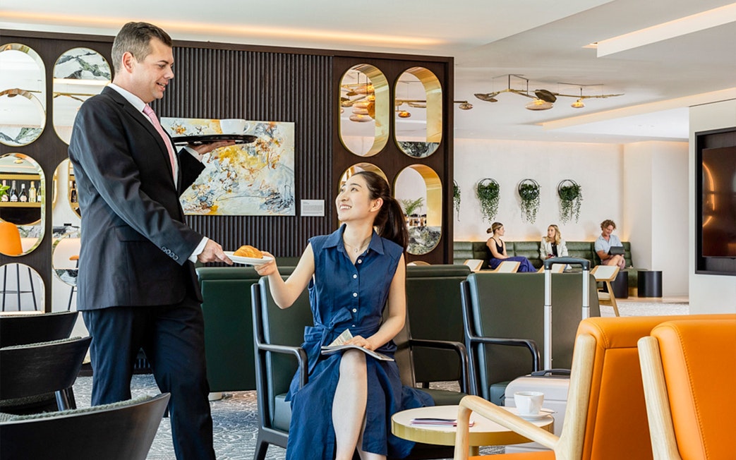 Server offering food to a guest at Plaza Premium Lounge.