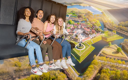 Guests enjoying the 5D Ultimate Flight Experience over a scenic landscape.