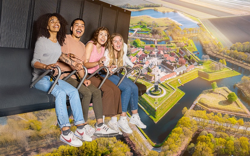 Guests enjoying the 5D Ultimate Flight Experience over a scenic landscape.