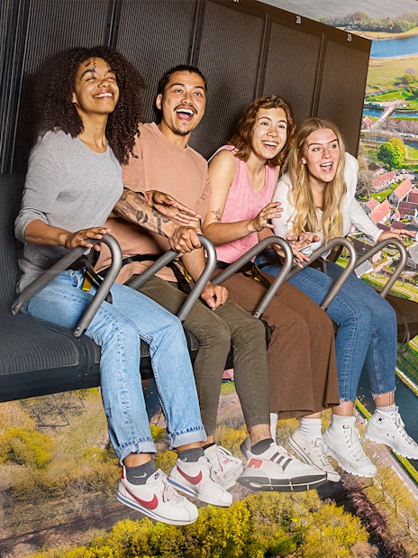 Guests enjoying the 5D Ultimate Flight Experience over a scenic landscape.