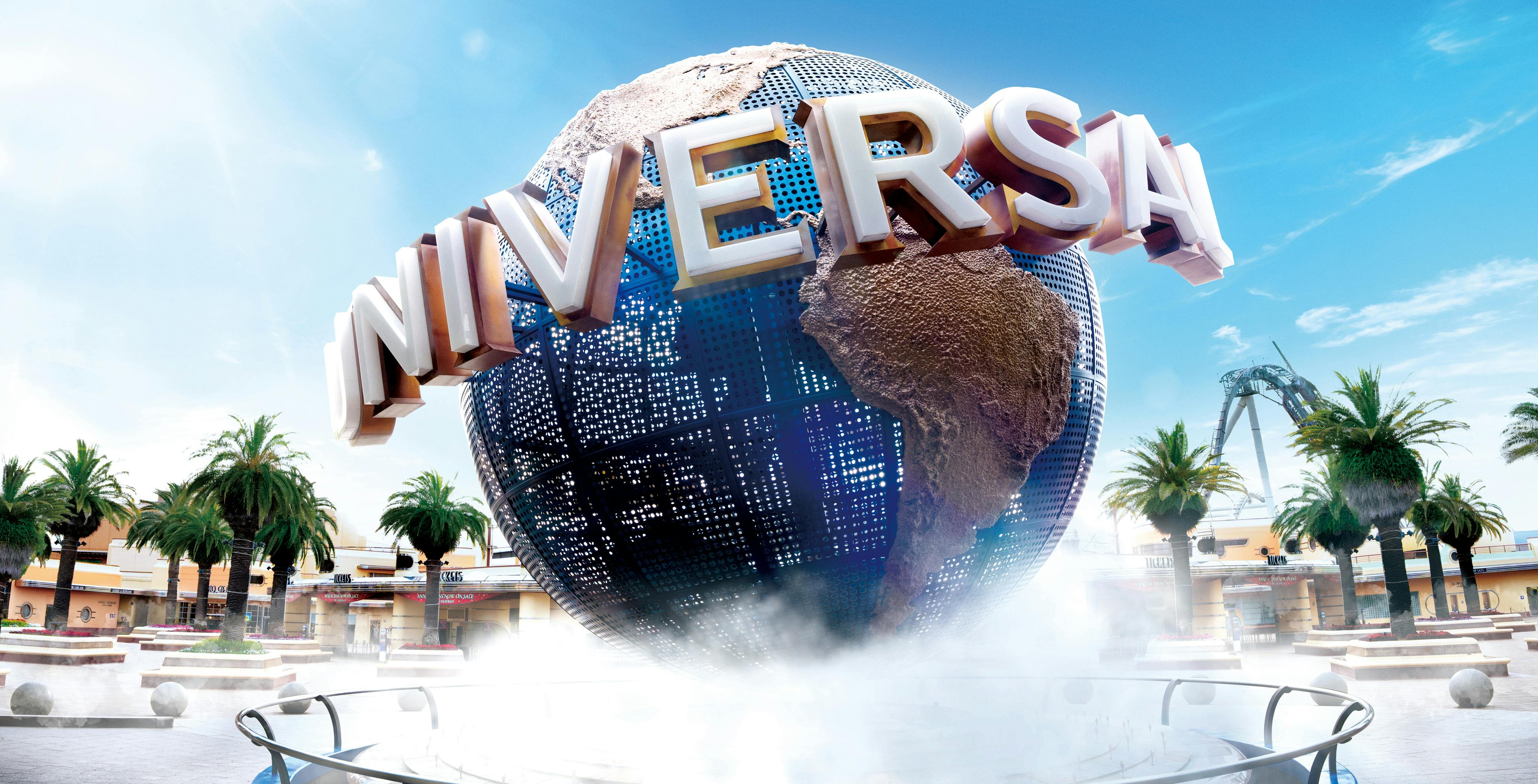 Universal Studios Japan globe with palm trees and attractions in the background.