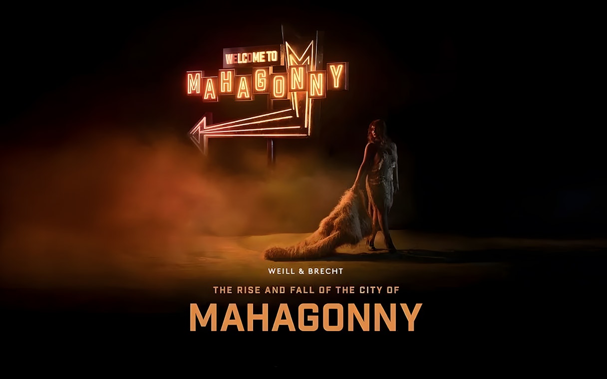 Neon sign reading 'Welcome to Mahagonny' with a person standing beside it, related to the Rise and Fall of The City of Mahagonny.